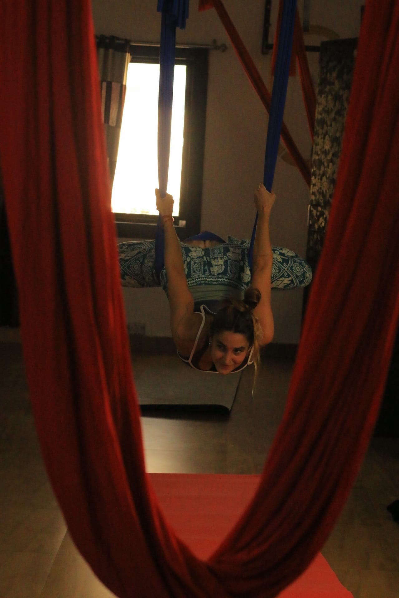 Student practicing aerial yoga inversion