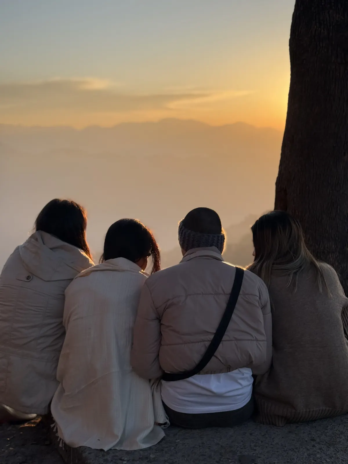 Students watching the sunrise over the Himalayan foothills from a hilltop near Rishikesh
