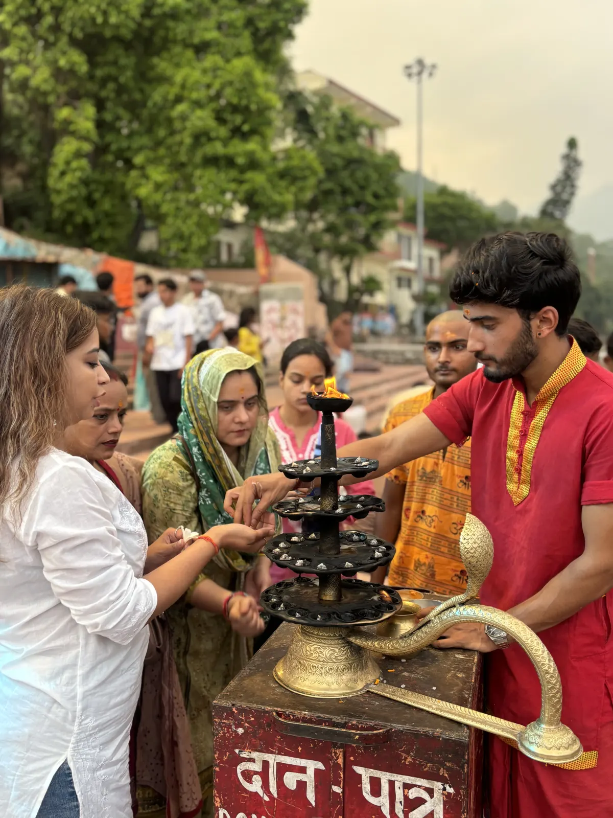 Students offering a brass lamp during a temple visit on a course excursion in Rishikesh