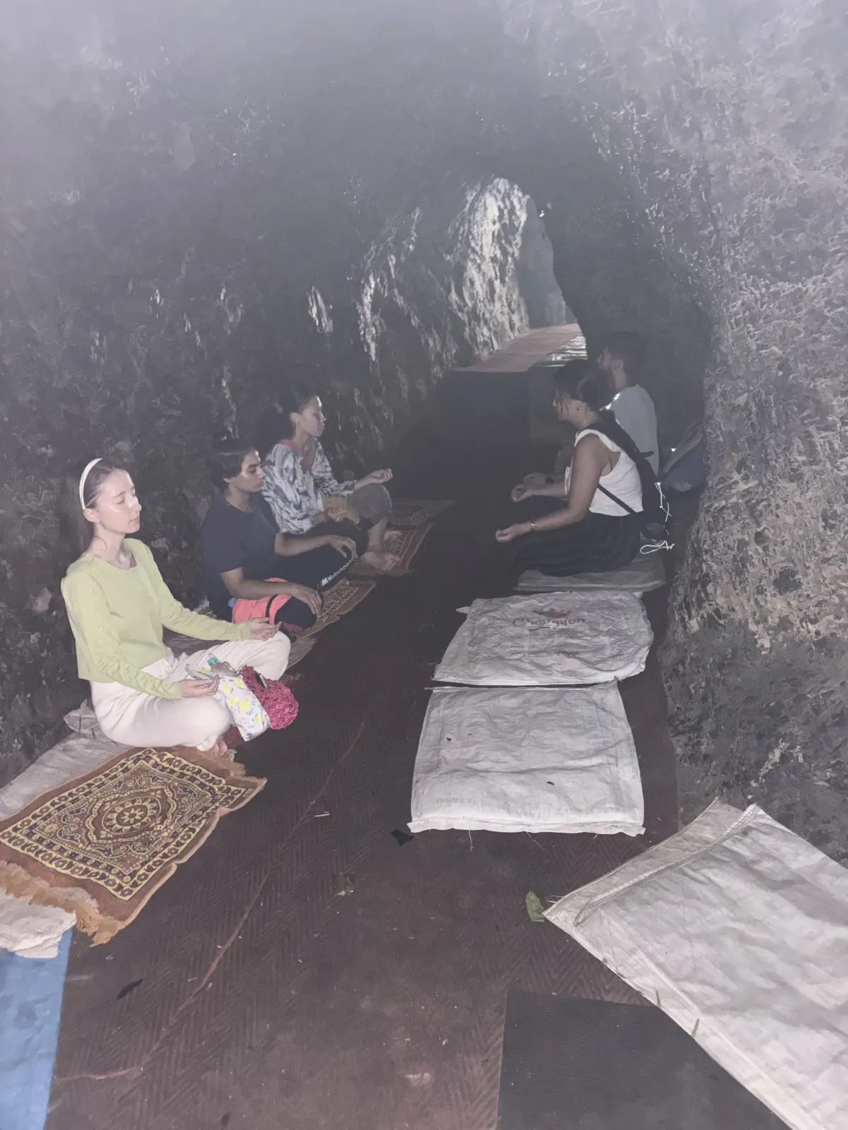 Students meditating inside a cave near Rishikesh on a yoga course excursion