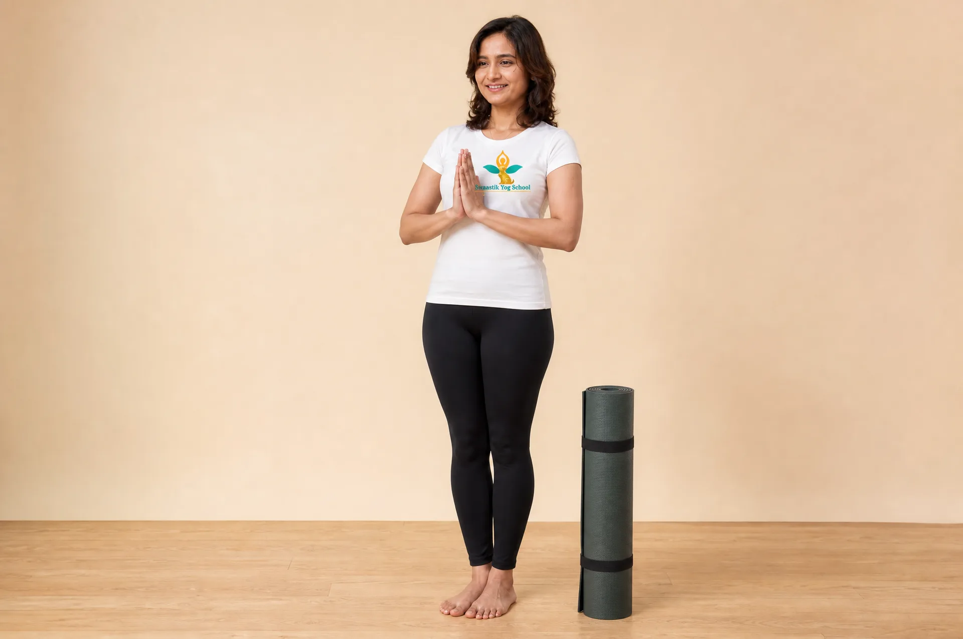 Certified professional yoga teacher standing in Tadasana with a rolled mat, ready to teach her own classes