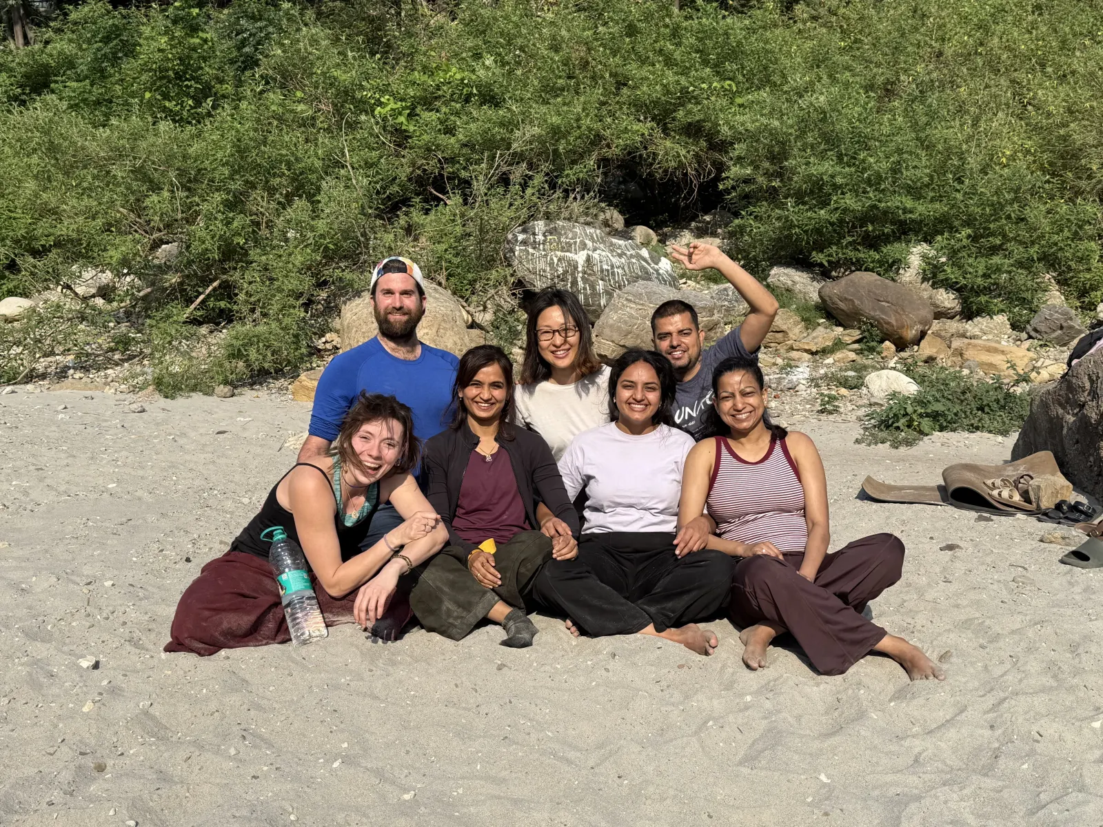 Yoga teacher training classmates relaxing together on the Ganga beach in Rishikesh during their free time