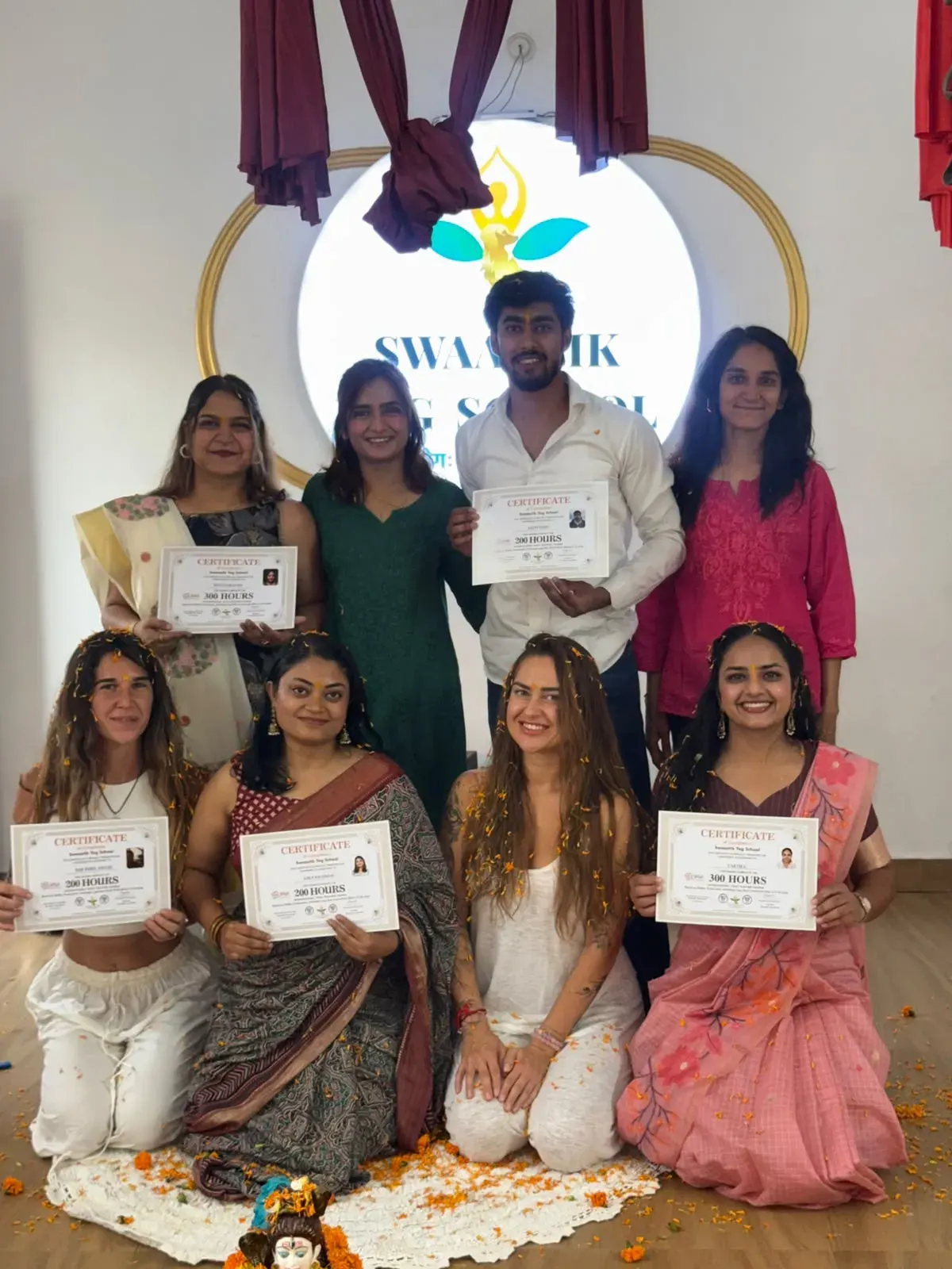 Graduates at Swaastik Yog School in Rishikesh holding their 300 hours and 200 hours yoga teacher training certificates after the closing ceremony