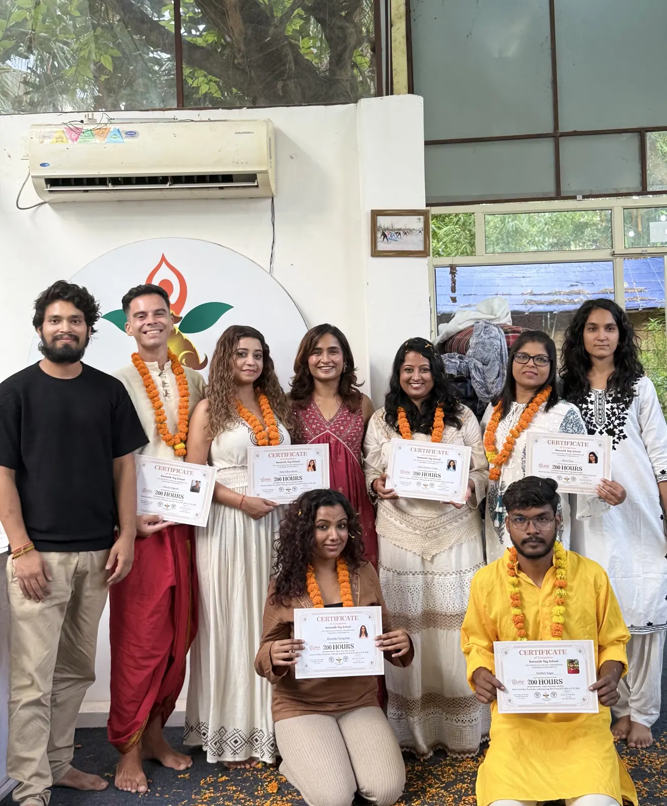 200 hour yoga teacher training graduates in marigold garlands holding their certificates at Swaastik Yog School, Rishikesh